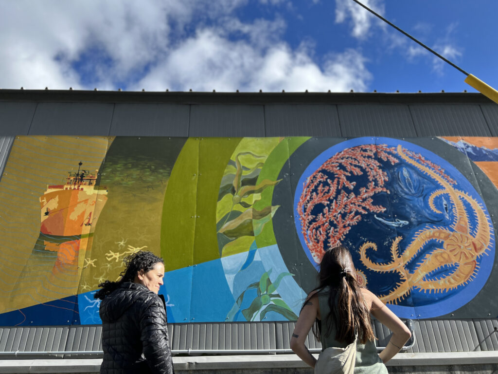 Seward-based artists Luzan Quintero (left) and Marissa Amor survey their work. The mural was designed by the artists based on imagery from the Seascape Alaska series of expeditions and painted by the artists and local community members.