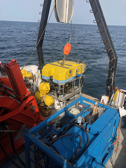ROV Odysseus being deployed while carrying an acoustic lander with attached microbial recruitment experiments for deployment on the seafloor.