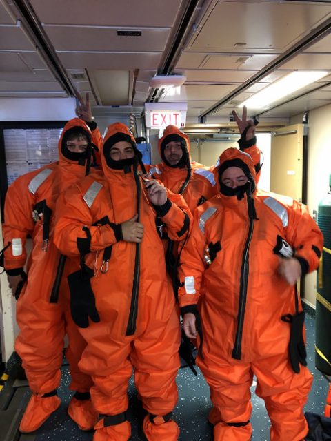 Science crew is practicing to put on the survival suits in case of an emergency.